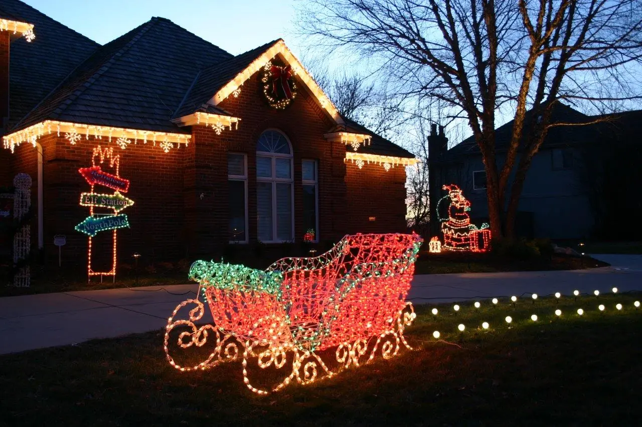 Illuminated Christmas sleigh display arranged in a residential lawn