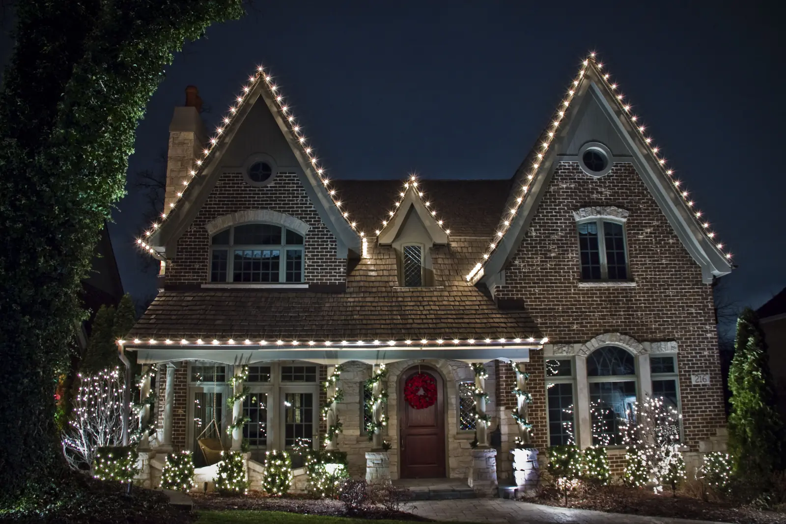 Christmas lighting services featuring classic white roofline lights on a traditional home