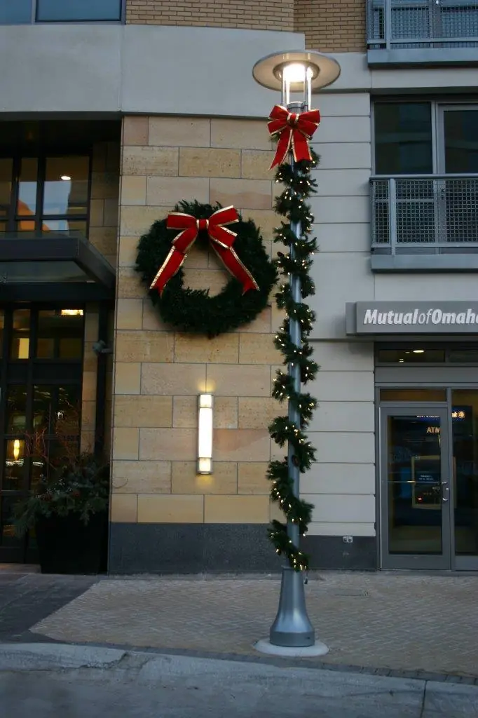 Commercial street pole decorated with wreath, garland, and white lights