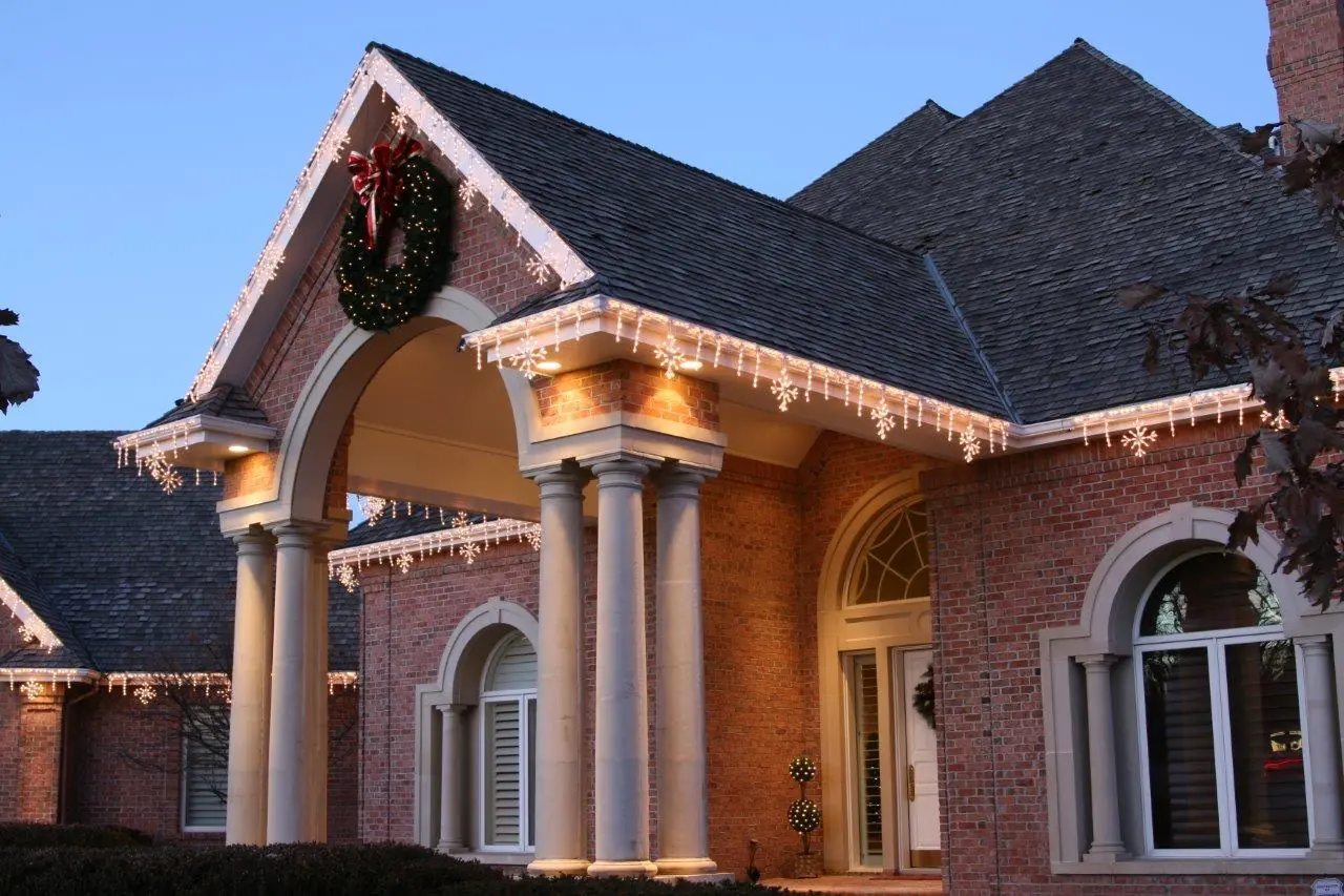 Large home decorated across the roofline, wreath, and front columns