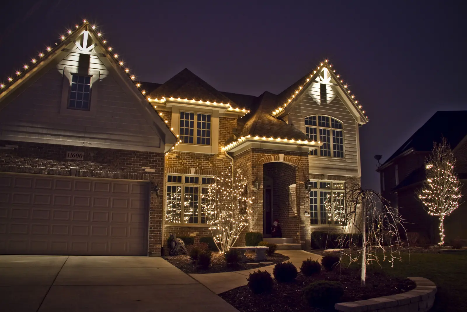 Stone home outlined with warm white roofline lights